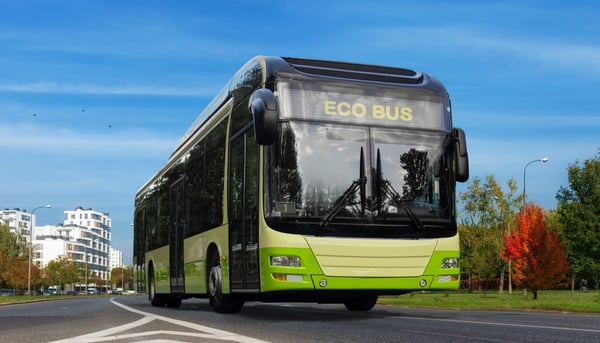 Eco Bus drives through city with trees in background 227364998